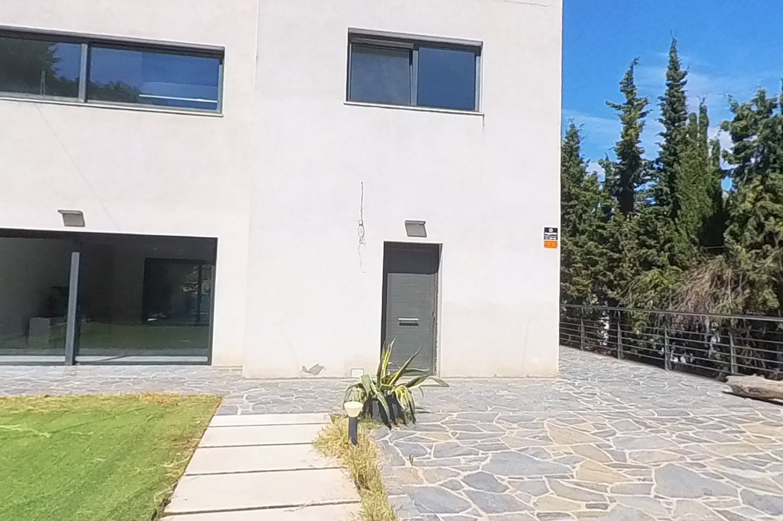 Fachada principal de la casa moderna con jardín