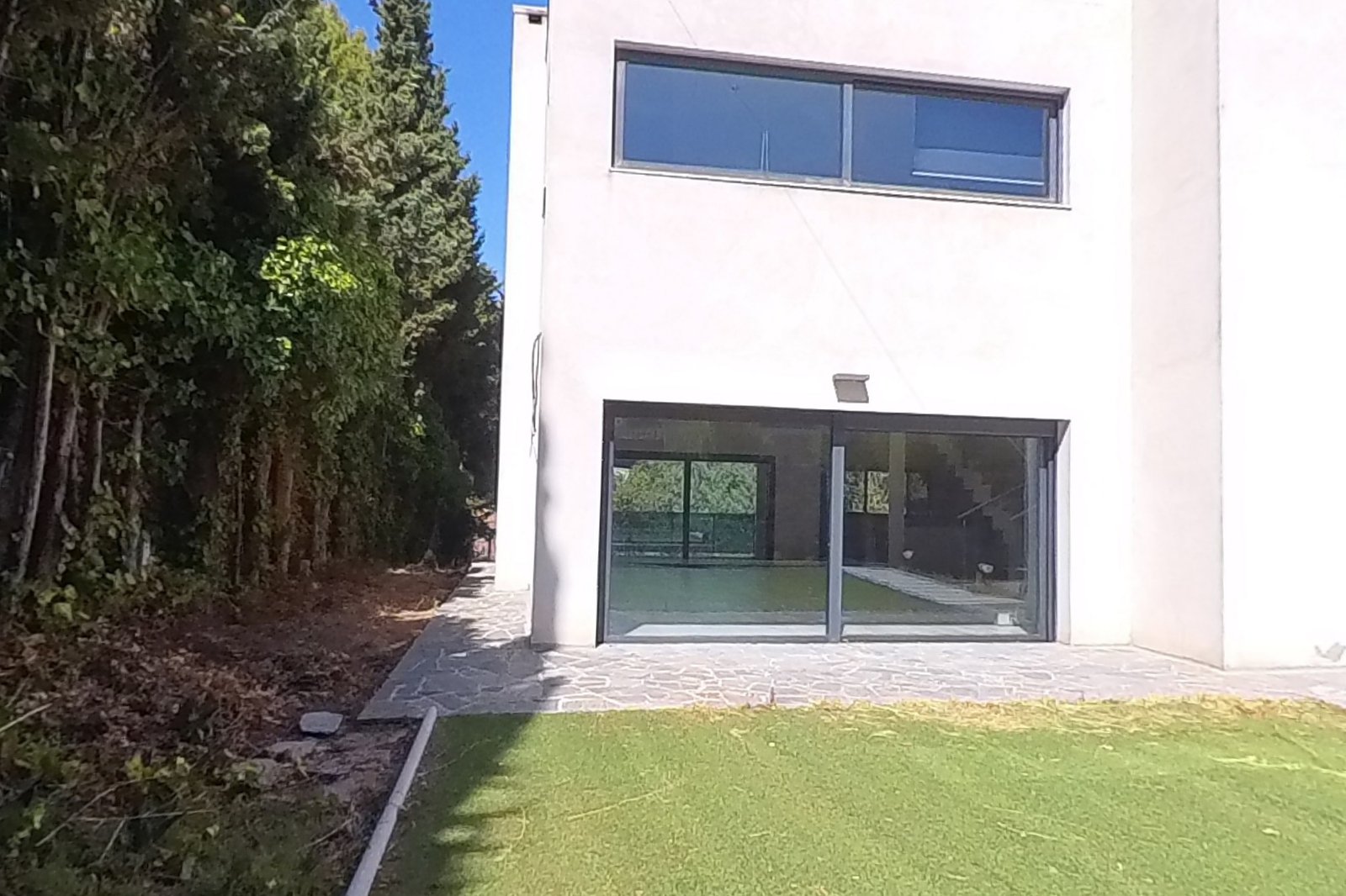 Jardín de la vivienda con césped y acceso al porche